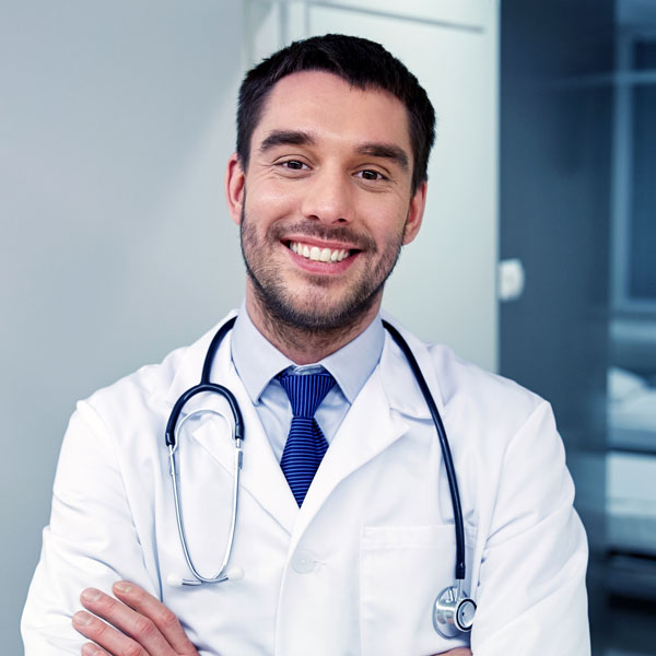 Smiling doctor with stethoscope at hospital PVS8FJU